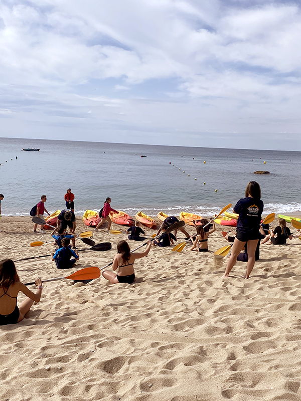 escolares en la playa con kayac